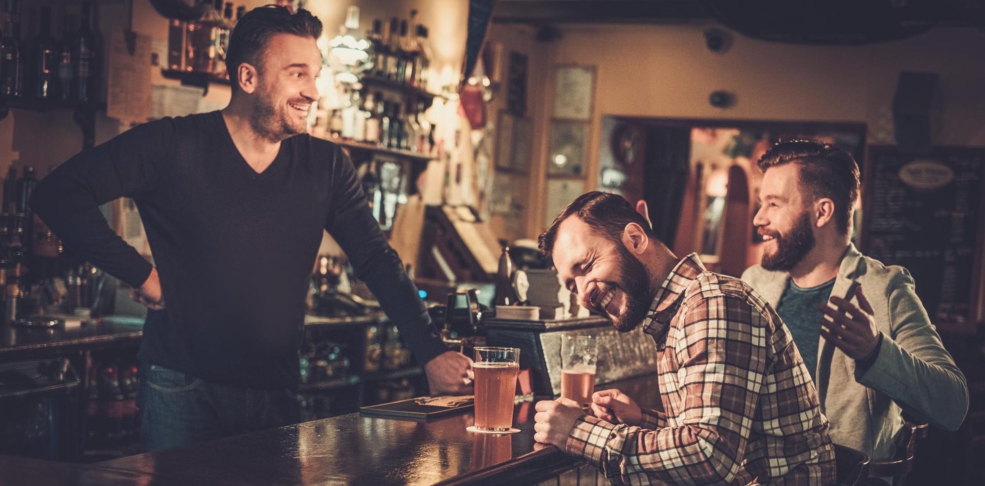 3 Men Laughing At A Bar