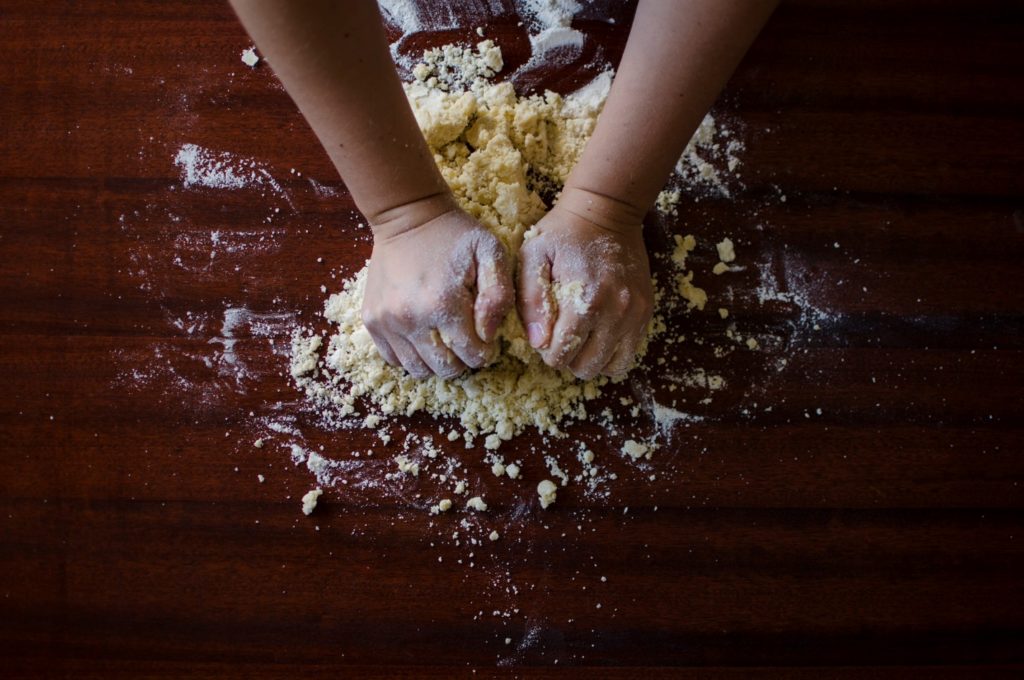 hands kneading the dough with flour